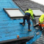 Roofers installing a new slate roof in Glasgow